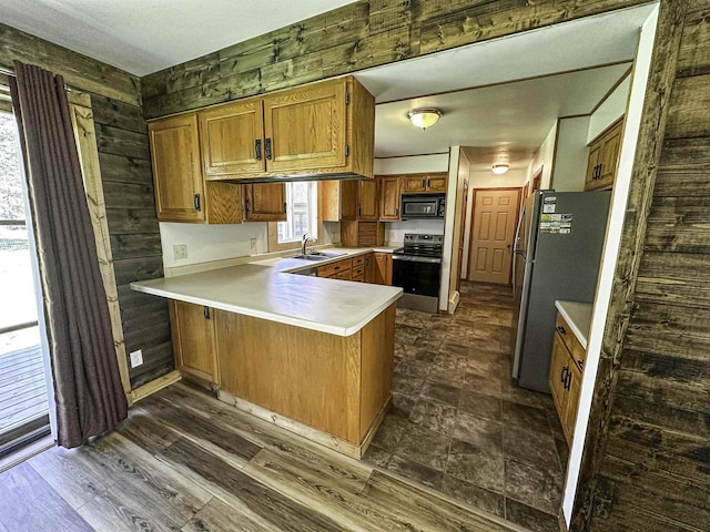 1200 4th Ave N, Park Falls, WI 54552 - kitchen with stainless steel appliances, a peninsula, brown cabinets, and light countertops