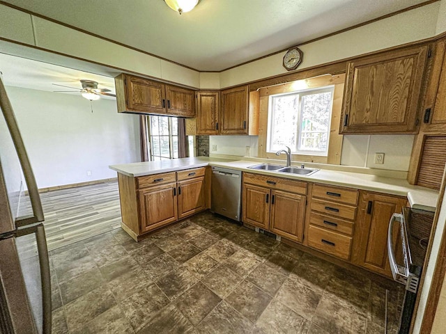 1200 4th Ave N, Park Falls, WI 54552 - kitchen featuring a sink, stainless steel dishwasher, a peninsula, brown cabinets, and light countertops