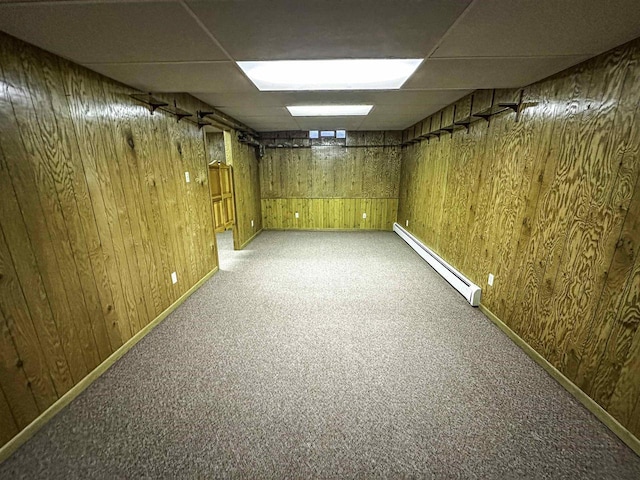 1200 4th Ave N, Park Falls, WI 54552 - finished below grade area with a baseboard heating unit, a drop ceiling, light colored carpet, wood walls, and baseboards