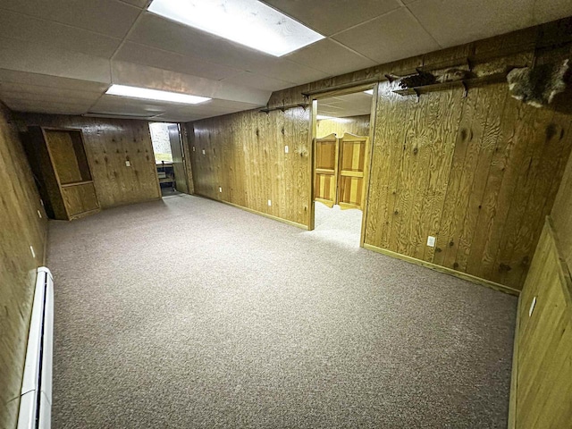 1200 4th Ave N, Park Falls, WI 54552 - basement featuring carpet floors, a drop ceiling, baseboard heating, wooden walls, and baseboards