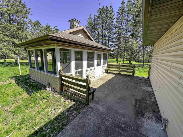 1200 4th Ave N, Park Falls, WI 54552 - view of home's exterior featuring a sunroom, roof with shingles, a chimney, and a lawn