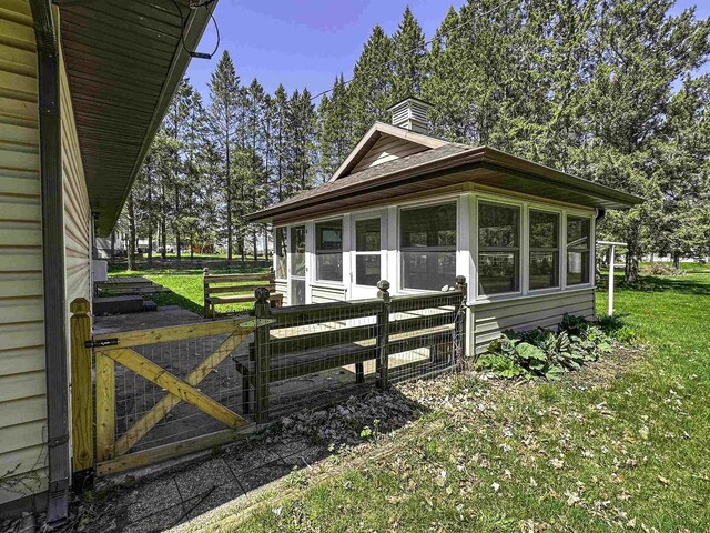 1200 4th Ave N, Park Falls, WI 54552 - view of home's exterior featuring a chimney, a gate, and a sunroom
