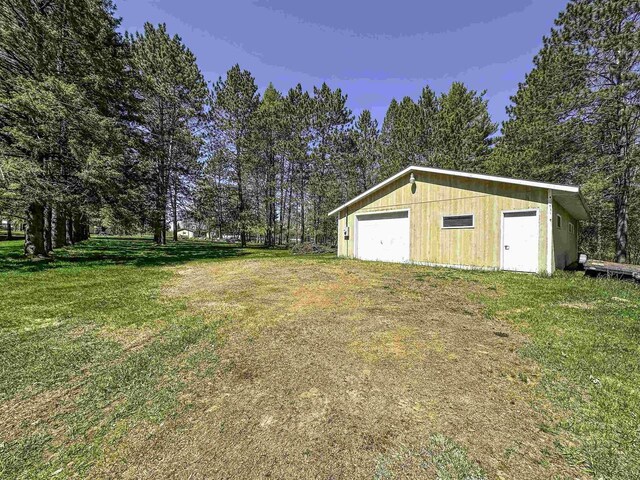 1200 4th Ave N, Park Falls, WI 54552 - view of green lawn featuring an outdoor structure and a detached garage