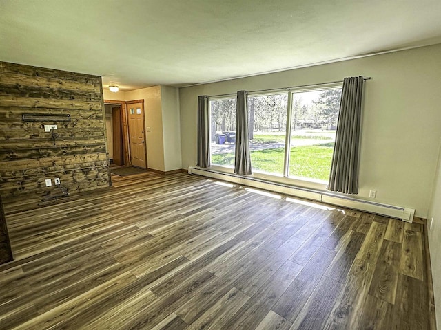 1200 4th Ave N, Park Falls, WI 54552 - unfurnished living room featuring wood finished floors, a baseboard heating unit, and baseboards