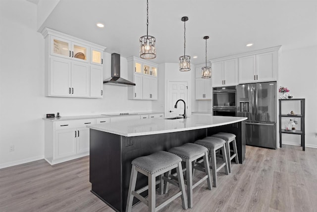 1150 S Bay Shore Rd, Brussels, WI 54204 - kitchen featuring stainless steel appliances, wall chimney exhaust hood, a sink, white cabinets, and a breakfast bar area