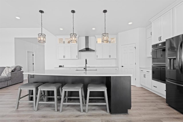 1150 S Bay Shore Rd, Brussels, WI 54204 - kitchen with black appliances, wall chimney range hood, a chandelier, light countertops, and light wood-type flooring