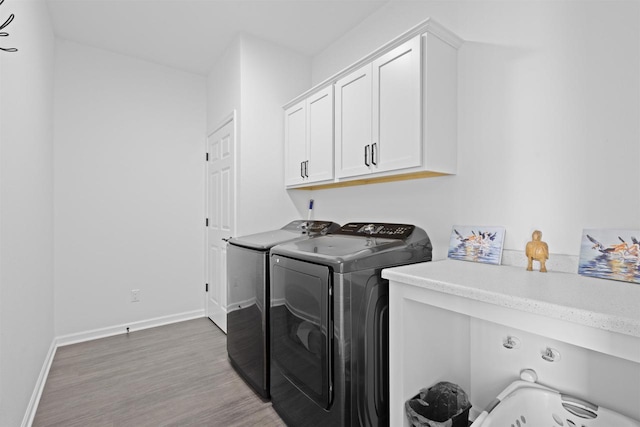 1150 S Bay Shore Rd, Brussels, WI 54204 - laundry area with washer and clothes dryer, cabinet space, light wood finished floors, and baseboards