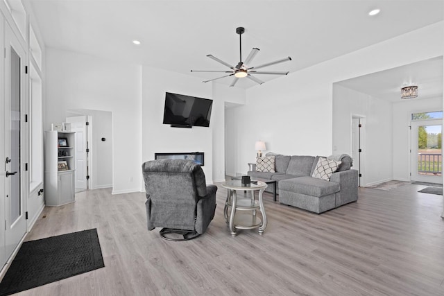1150 S Bay Shore Rd, Brussels, WI 54204 - living room featuring light wood finished floors, a glass covered fireplace, a ceiling fan, recessed lighting, and baseboards