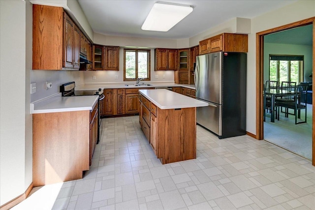 6460 Shady Bend Rd, Verona, WI 53593 - kitchen featuring freestanding refrigerator, black range with electric cooktop, under cabinet range hood, a sink, and brown cabinets