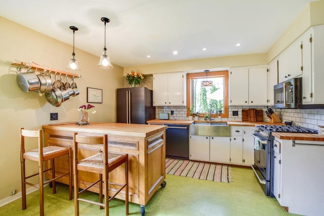 5102 Marathon Dr, Madison, WI 53705 - kitchen with stainless steel appliances, a sink, tasteful backsplash, white cabinets, and wood counters