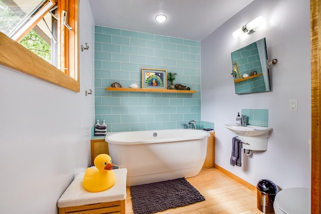 5102 Marathon Dr, Madison, WI 53705 - full bath featuring wood finished floors, a soaking tub, toilet, and baseboards