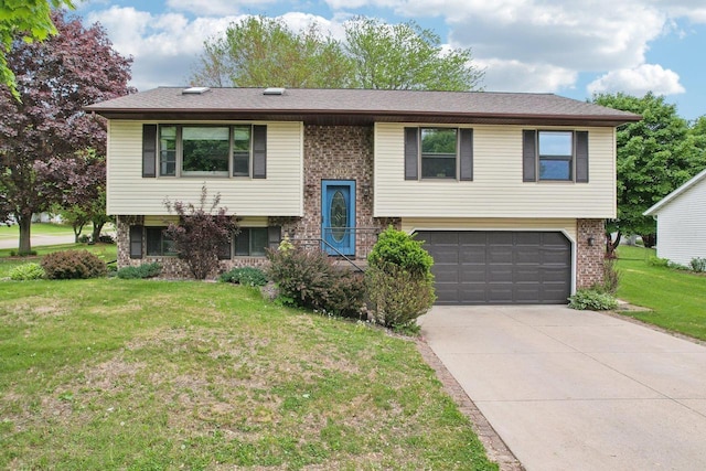 1902 Winfield Dr, Reedsburg, WI 53959 - bi-level home with a garage, driveway, brick siding, and a front yard