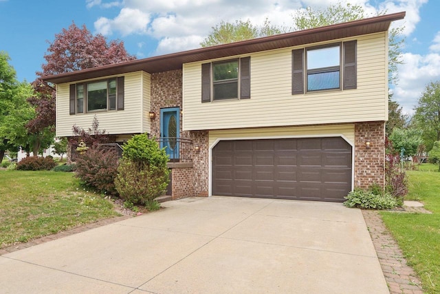 1902 Winfield Dr, Reedsburg, WI 53959 - split foyer home with brick siding, an attached garage, concrete driveway, and a front yard