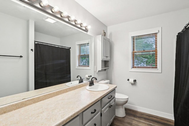 1902 Winfield Dr, Reedsburg, WI 53959 - bathroom featuring baseboards, wood finished floors, toilet, and plenty of natural light