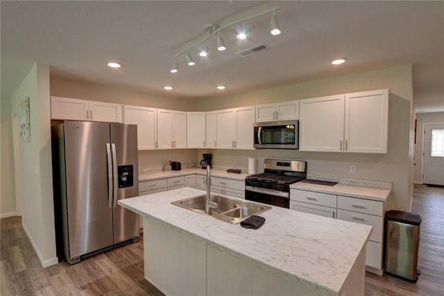10246 Olker Rd, Hayward, WI 54843 - kitchen featuring stainless steel appliances, wood finished floors, white cabinets, a kitchen island with sink, and recessed lighting