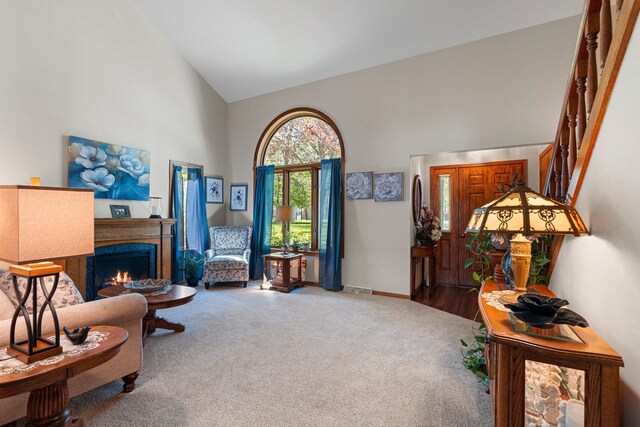 N3154 River Bend Dr, Peshtigo, WI 54157 - living area with high vaulted ceiling, carpet flooring, a lit fireplace, and baseboards