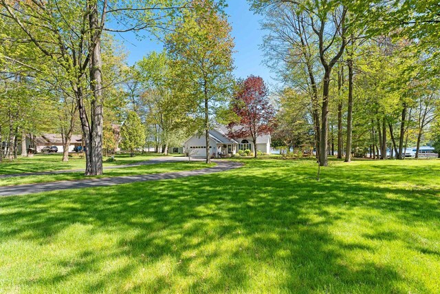 N3154 River Bend Dr, Peshtigo, WI 54157 - view of community with asphalt driveway, an attached garage, and a yard