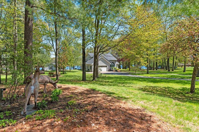 N3154 River Bend Dr, Peshtigo, WI 54157 - view of grassy yard with asphalt driveway and a garage