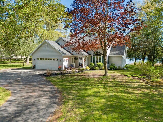 N3154 River Bend Dr, Peshtigo, WI 54157 - view of front of home featuring driveway, an attached garage, a front lawn, and covered porch