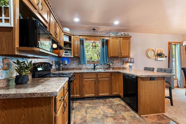 N3154 River Bend Dr, Peshtigo, WI 54157 - kitchen with black appliances, a sink, a peninsula, a breakfast bar area, and brown cabinets
