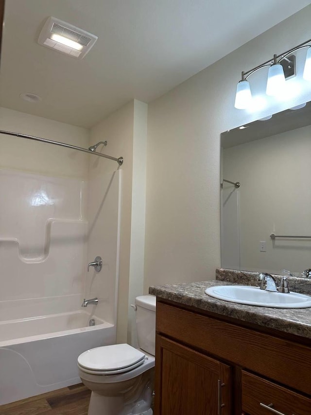 513 Oak Grove Dr, Necedah, WI 54646 - full bath featuring toilet, vanity, shower / bath combination, and wood finished floors