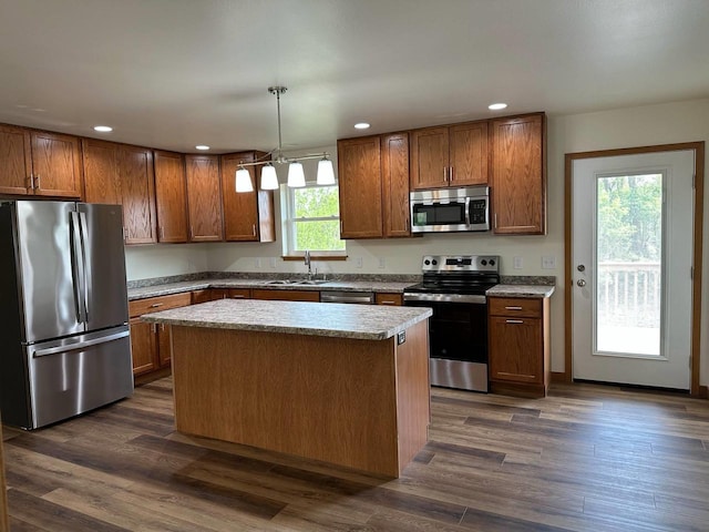 513 Oak Grove Dr, Necedah, WI 54646 - kitchen with stainless steel appliances, a kitchen island, brown cabinets, recessed lighting, and hanging light fixtures