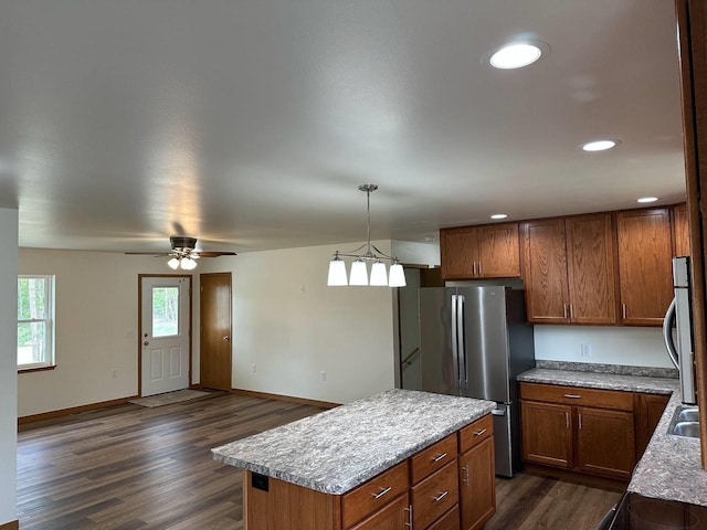 513 Oak Grove Dr, Necedah, WI 54646 - kitchen featuring freestanding refrigerator, brown cabinetry, dark wood-style flooring, a kitchen island, and recessed lighting