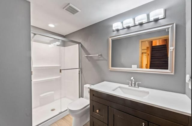2605 River Ridge Drive, Waukesha, WI 53189 - bathroom featuring toilet, vanity, a stall shower, and wood finished floors