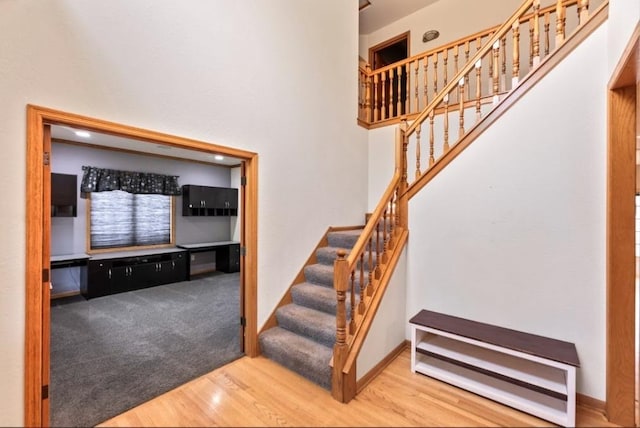 2605 River Ridge Drive, Waukesha, WI 53189 - stairway featuring wood finished floors, a towering ceiling, and baseboards