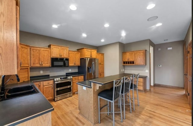 2605 River Ridge Drive, Waukesha, WI 53189 - kitchen featuring stainless steel appliances, dark countertops, a sink, a breakfast bar area, and recessed lighting