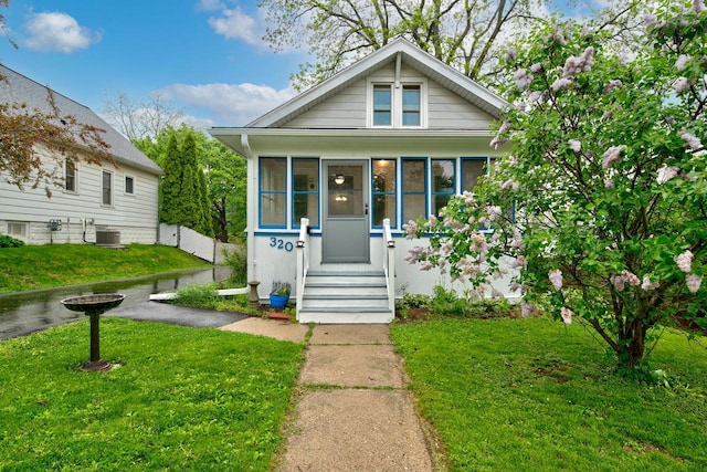 320 Frederick St, Waukesha, WI 53186 - bungalow with a front yard, a sunroom, and central AC unit