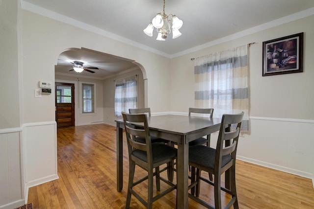 320 Frederick St, Waukesha, WI 53186 - dining area featuring arched walkways, light wood finished floors, a chandelier, wainscoting, and crown molding