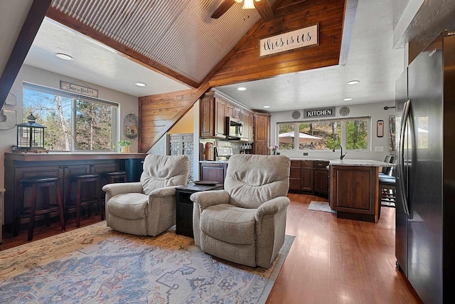 15393 Jacklin Heights Cir, Crivitz, WI 54114 - living area featuring plenty of natural light, light wood-style floors, a bar, ceiling fan, and wood walls