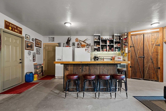 15393 Jacklin Heights Cir, Crivitz, WI 54114 - bar featuring freestanding refrigerator, white fridge with ice dispenser, a barn door, and concrete flooring