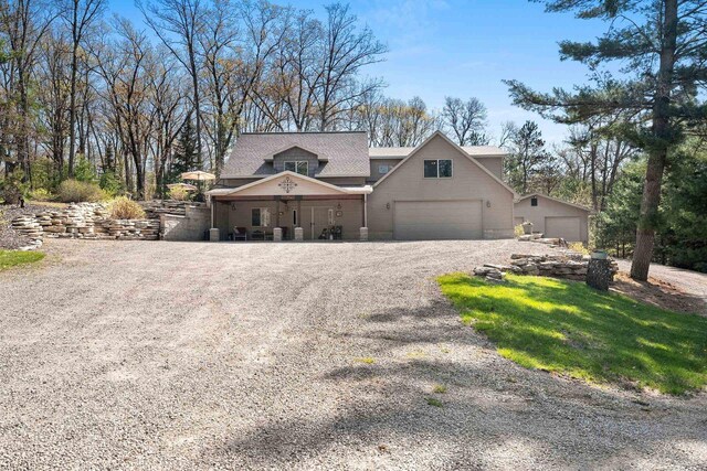 15393 Jacklin Heights Cir, Crivitz, WI 54114 - view of front of house with a garage, gravel driveway, roof with shingles, and a porch