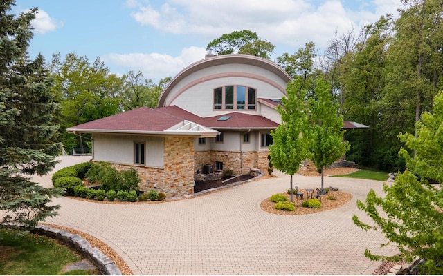 58 Oakridge Ct, Fond Du Lac, WI 54937 - view of front of house with curved driveway and stone siding