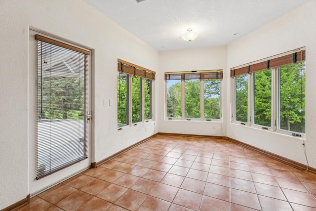 58 Oakridge Ct, Fond Du Lac, WI 54937 - unfurnished sunroom featuring plenty of natural light, tile patterned floors, and baseboards