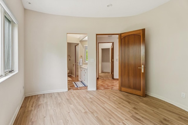 58 Oakridge Ct, Fond Du Lac, WI 54937 - unfurnished bedroom with light wood-style flooring, baseboards, and ensuite bath