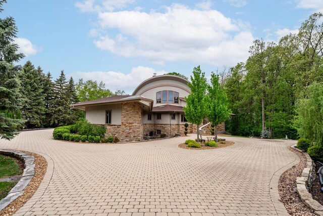 58 Oakridge Ct, Fond Du Lac, WI 54937 - view of front of property featuring curved driveway and stone siding