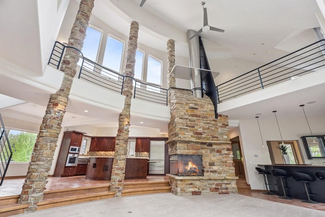 58 Oakridge Ct, Fond Du Lac, WI 54937 - living room with ornate columns, a high ceiling, and a multi sided fireplace