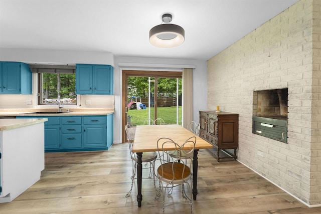 522 Valley Rd, Madison, WI 53714 - kitchen featuring blue cabinets, a sink, light countertops, and brick wall