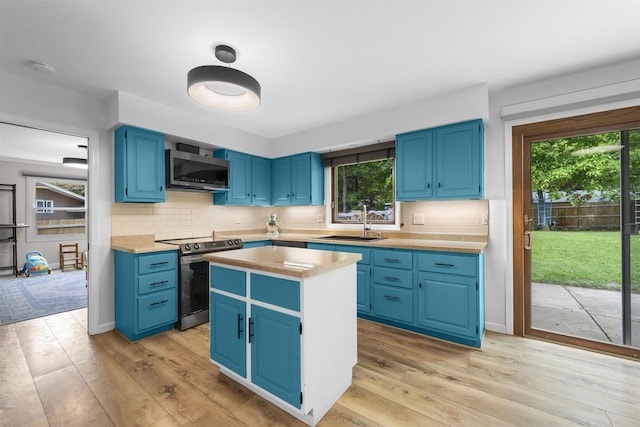 522 Valley Rd, Madison, WI 53714 - kitchen with appliances with stainless steel finishes, blue cabinetry, a sink, and light wood finished floors
