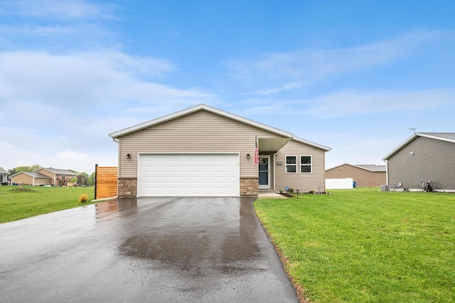 900 Edgewater Dr, Merrill, WI 54452 - ranch-style house featuring a front yard, driveway, stone siding, and an attached garage