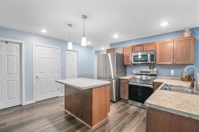 900 Edgewater Dr, Merrill, WI 54452 - kitchen featuring appliances with stainless steel finishes, a sink, dark wood-style flooring, light countertops, and a kitchen island
