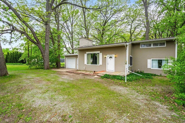 6429 S US Highway 45, Oshkosh, WI 54902 - view of front of property with a chimney, an attached garage, a front lawn, and driveway