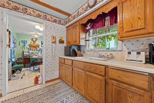 N8991 E Miramar Dr Unit N8993, East Troy, WI 53120 - kitchen featuring a sink, wallpapered walls, light countertops, brown cabinets, and light tile patterned floors