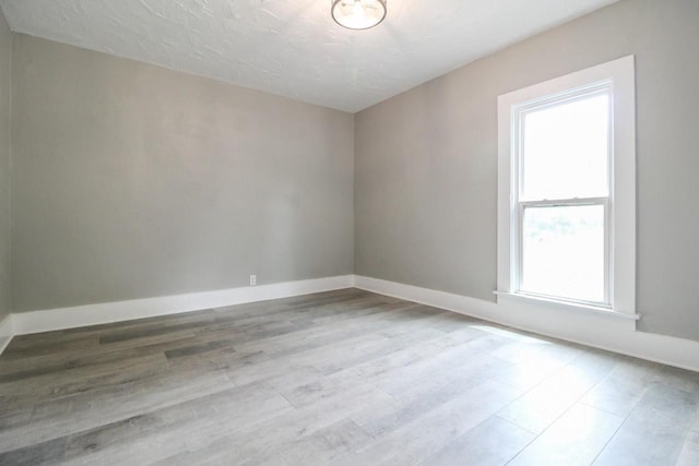 139 S Church St, Whitewater, WI 53190 - spare room featuring wood finished floors, baseboards, and a textured ceiling
