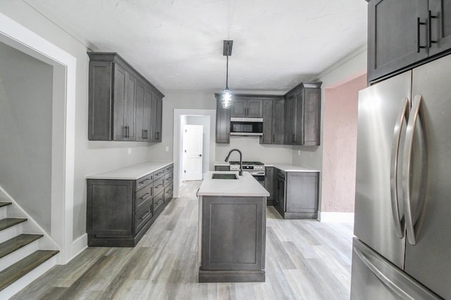139 S Church St, Whitewater, WI 53190 - kitchen with stainless steel appliances, a center island with sink, light wood-style flooring, a sink, and baseboards