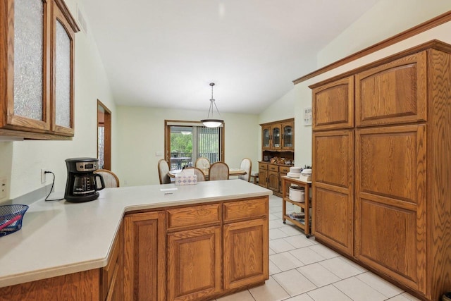 615 Jefferson St, Waterloo, WI 53594 - kitchen with lofted ceiling, a peninsula, brown cabinets, light countertops, and light tile patterned flooring