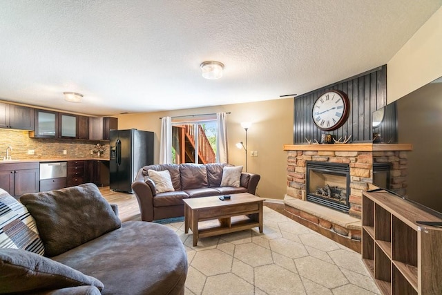 3829 Nicholas Dr, Menomonie, WI 54751 - living room featuring a stone fireplace, light wood-style floors, and a textured ceiling